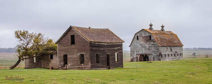an old abandoned house in front of a delightful barn