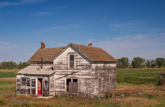 A once-white house sports a red door