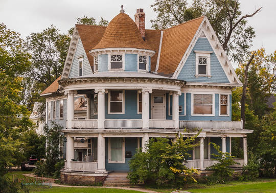 an old victorian house with a turret & balconies