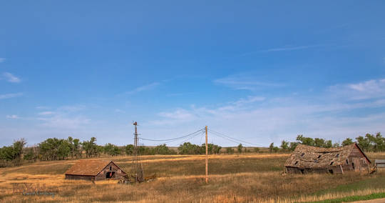 two farm buildings and a broken windmill