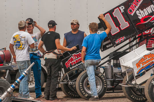 drivers and crew discuss somethign in the pit