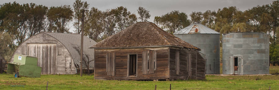 a saltbox house abandoned in a field.